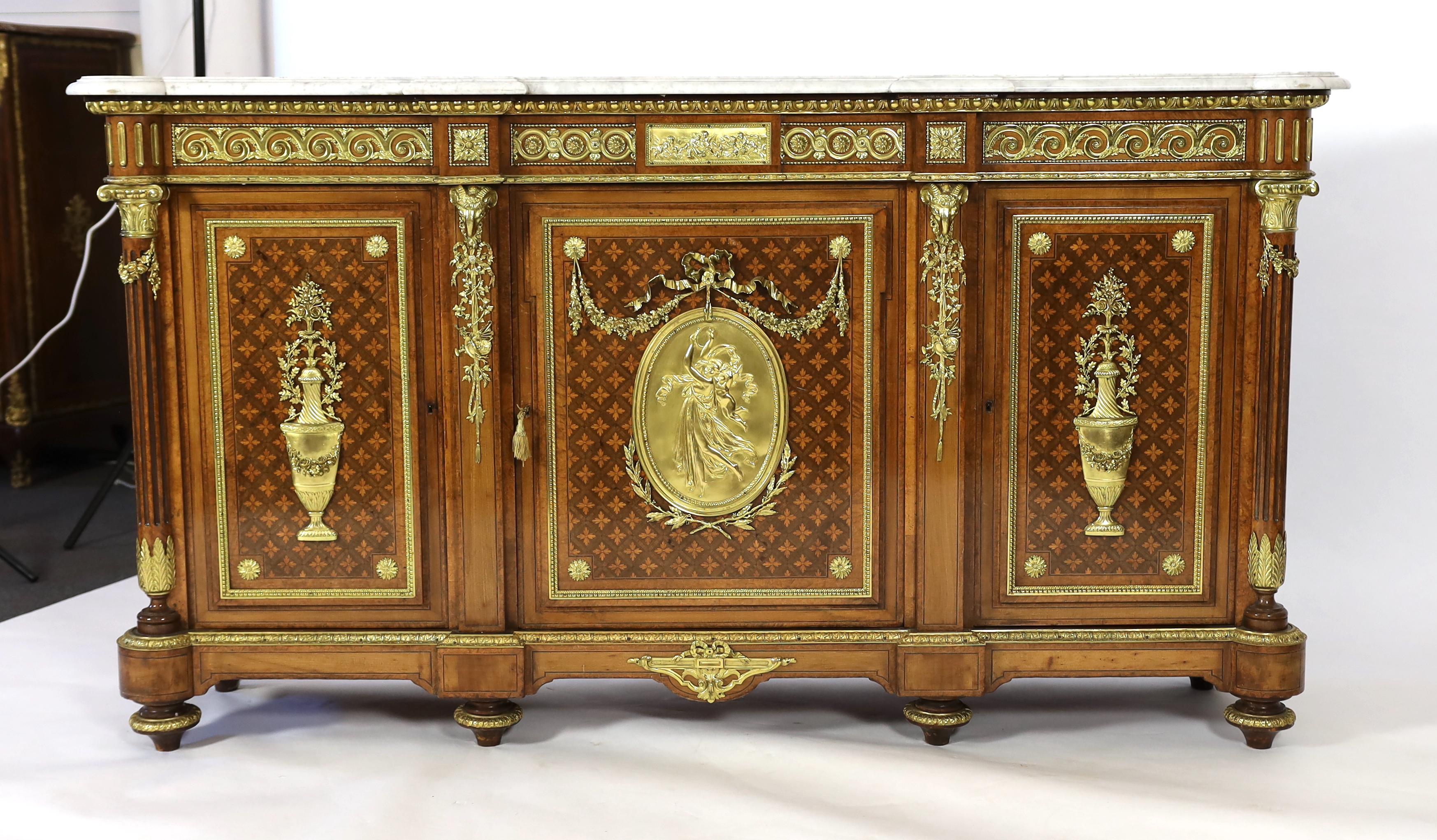 A Louis XVI style amboyna, tulipwood and harewood marquetry side cabinet, in the manner of Adam Weisweiler (1744-1820), 210cm wide, 48cm deep, 115cm high, Please note this lot attracts an additional import tax of 5% on t
